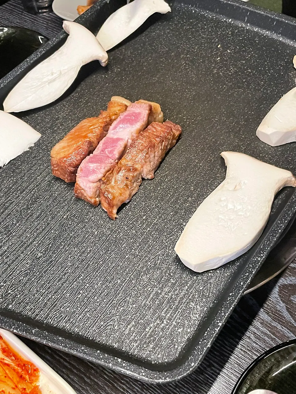 Staff member grilling the meat at the table