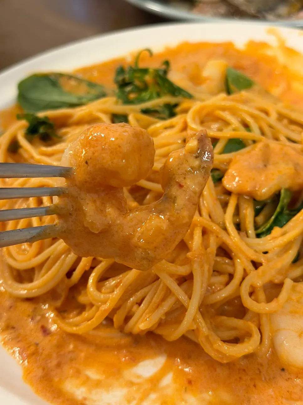 Scooping a portion of shrimp rosé pasta