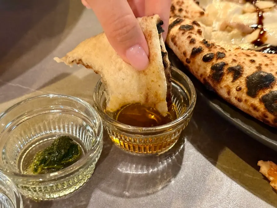 Pizza served with piccante oil and basil pesto