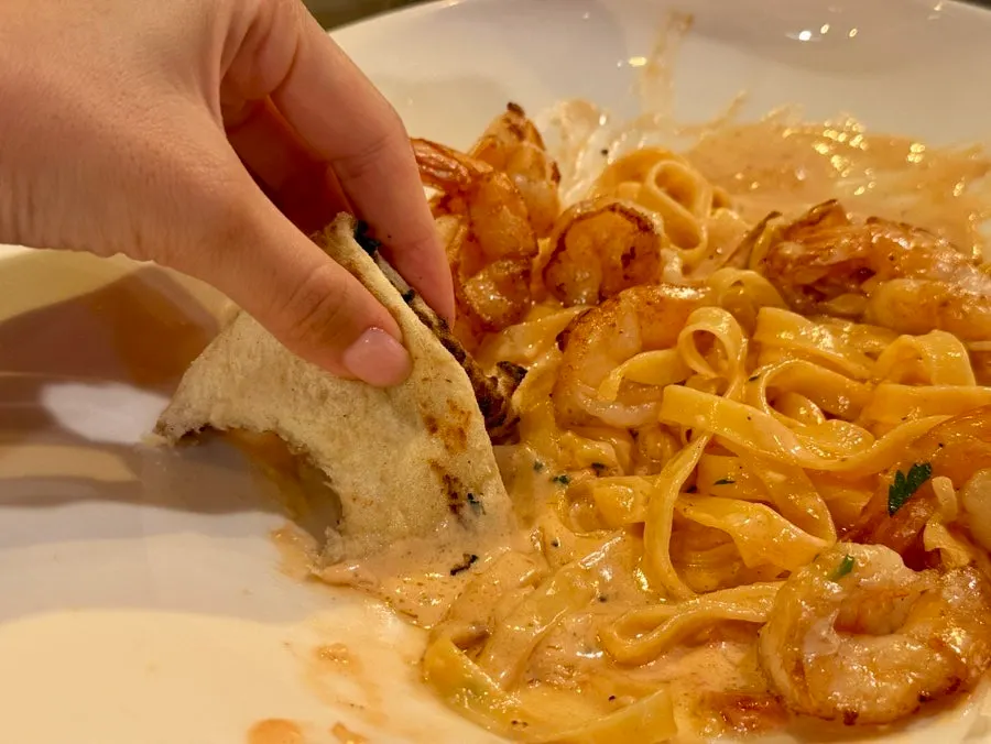 Dipping pizza crust into rose pasta sauce
