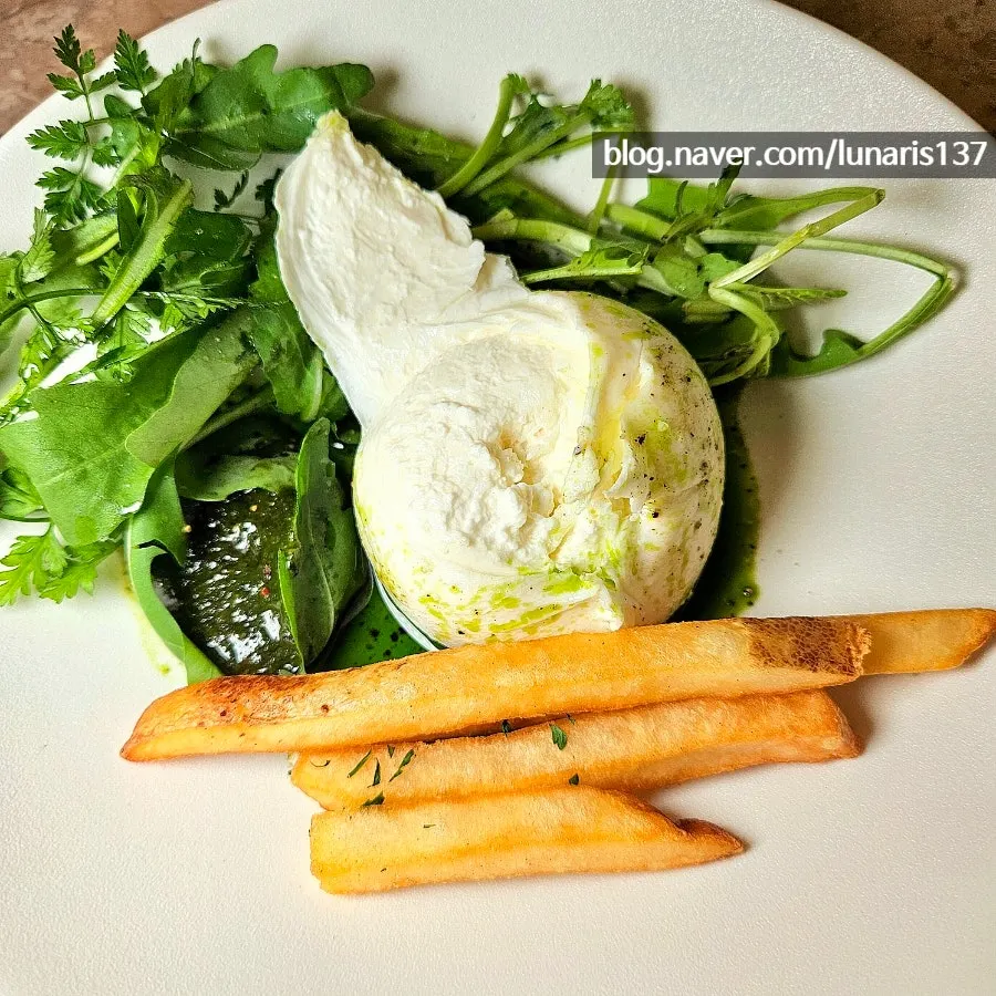 A large ball of burrata cheese cut open with a knife