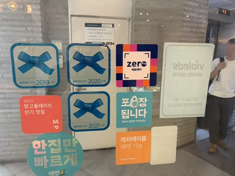 Entrance with Blue Ribbon and Mango Plate award signage