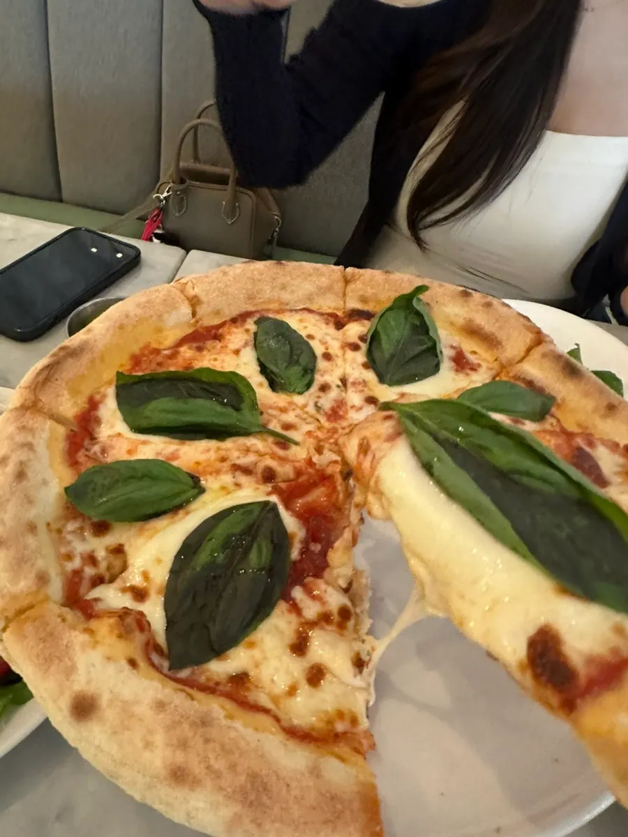 A slice of Margherita pizza with generous mozzarella