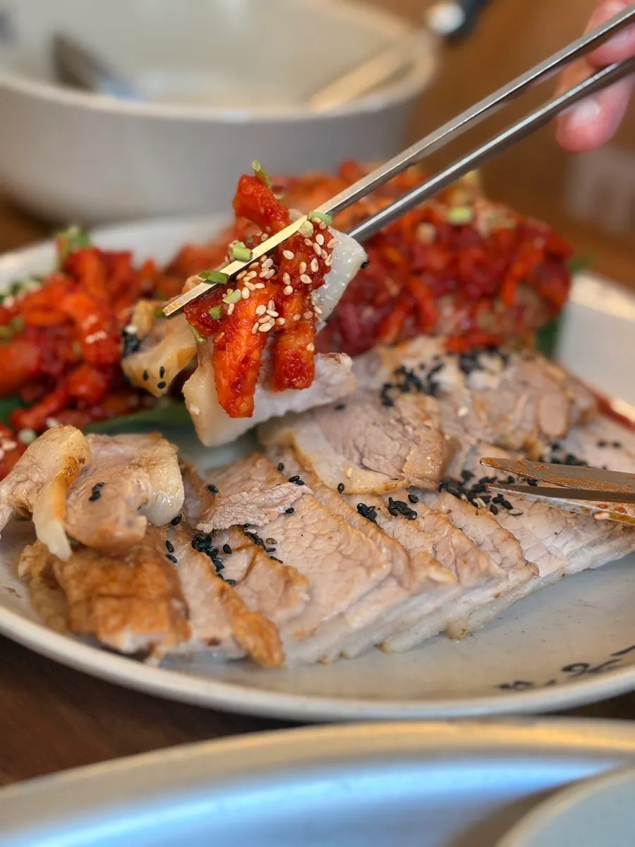 A piece of bossam topped with bossam kimchi