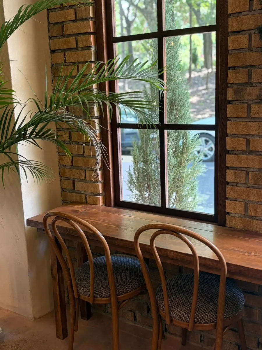 Mesa junto a la ventana decorada con plantas