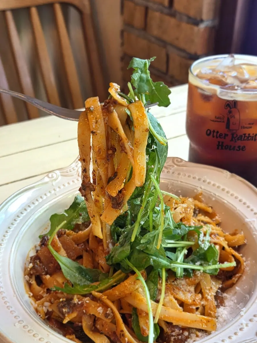Bolognese ragu pasta topped with arugula