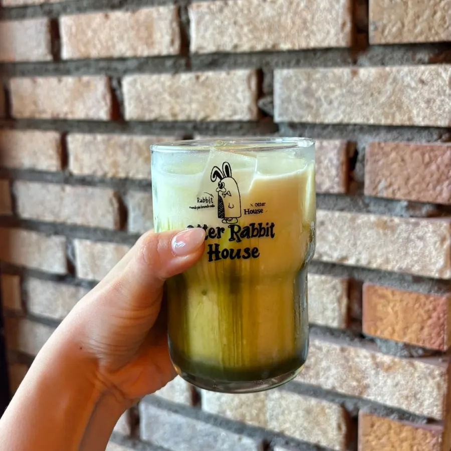 A glass of matcha latte with matcha settled at the bottom