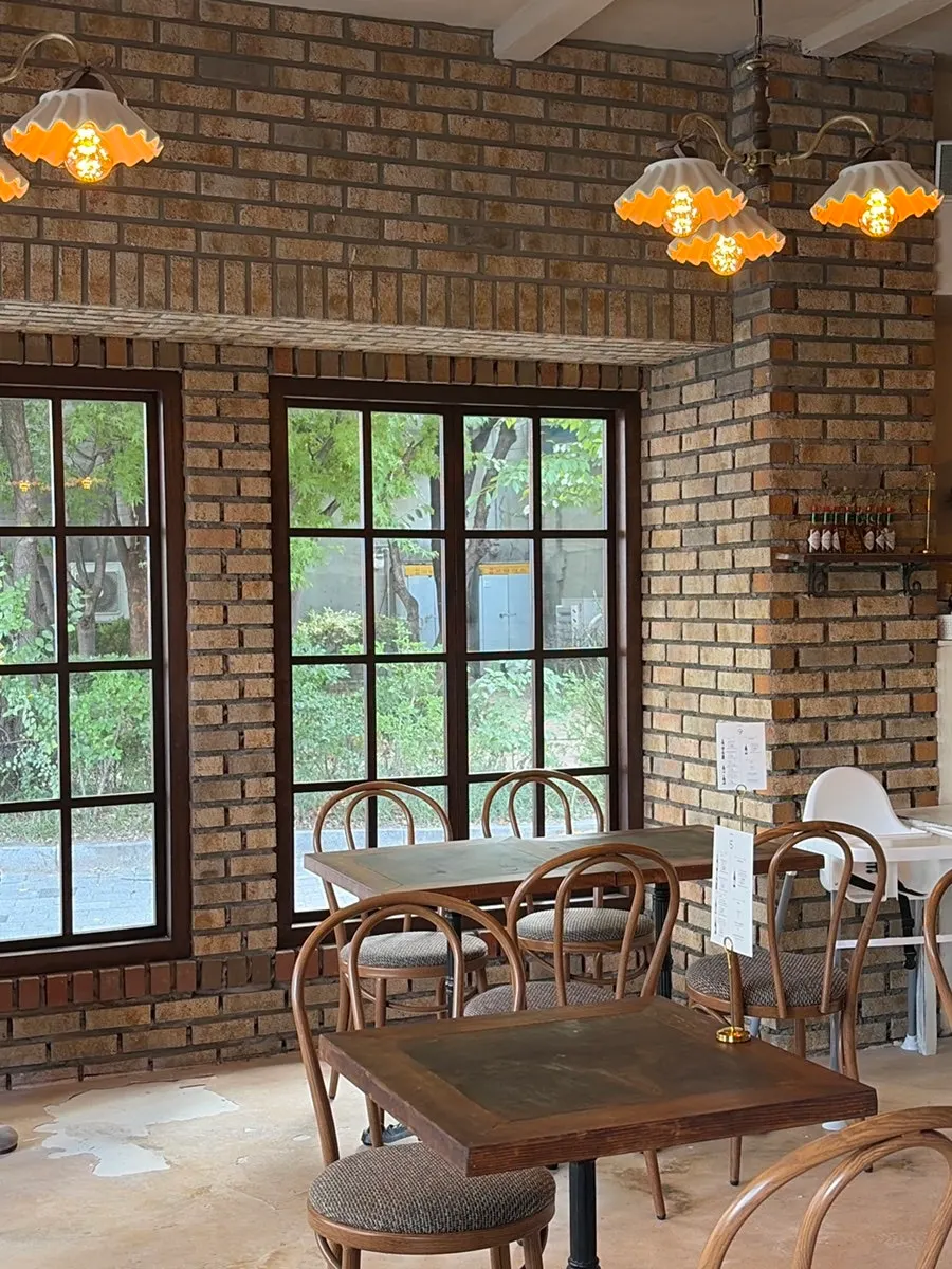 Interior with green plants visible through the floor-to-ceiling window