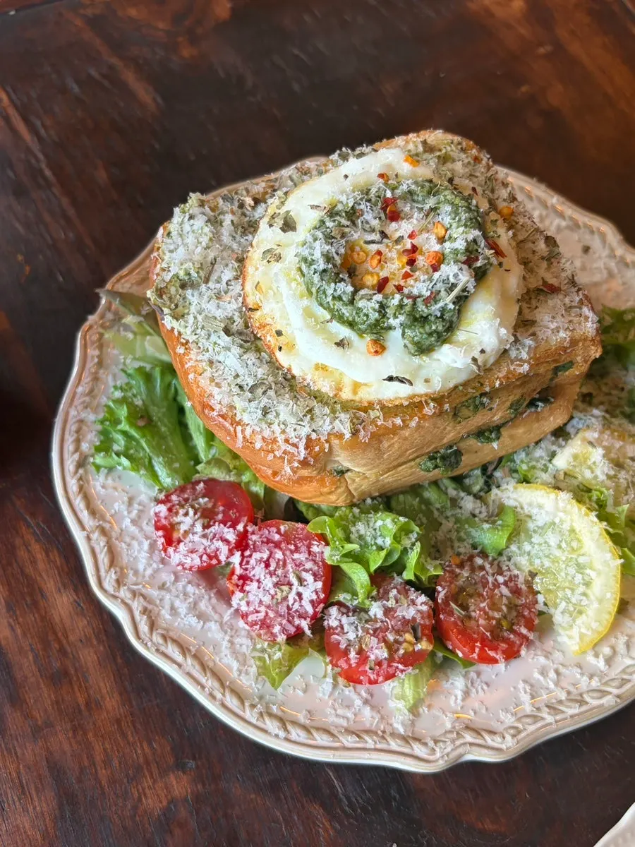 Plate of toast topped with egg and basil