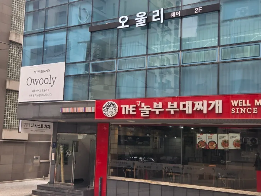 Exterior of the Owlly Yeoksam Branch building with the Nolbu Budae-jjigae sign on the 1st floor