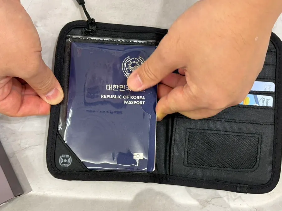 Black passport case chosen to match travel outfits