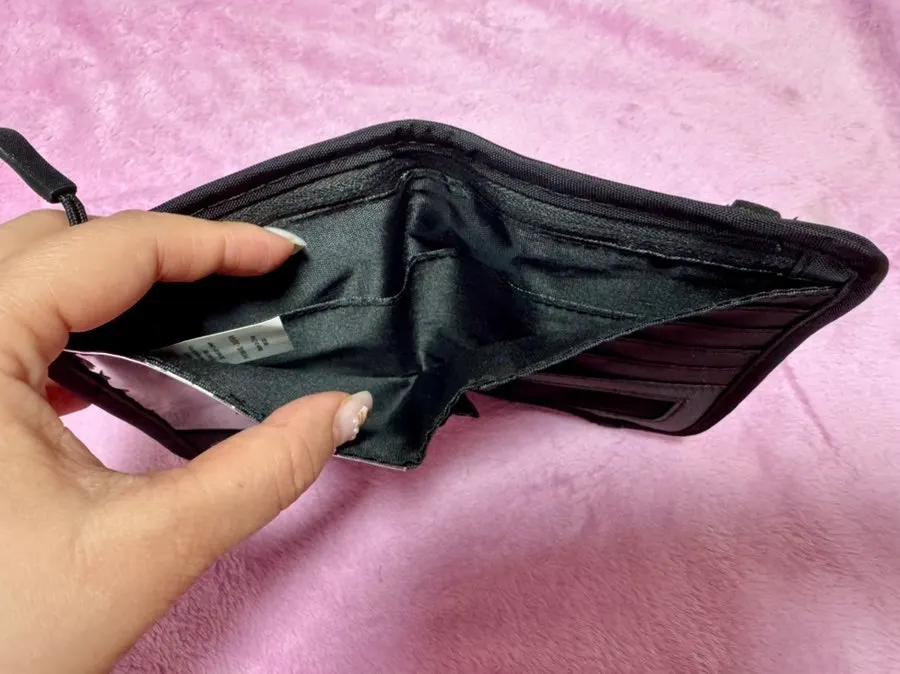 Black Packly wallet holding a passport and cards