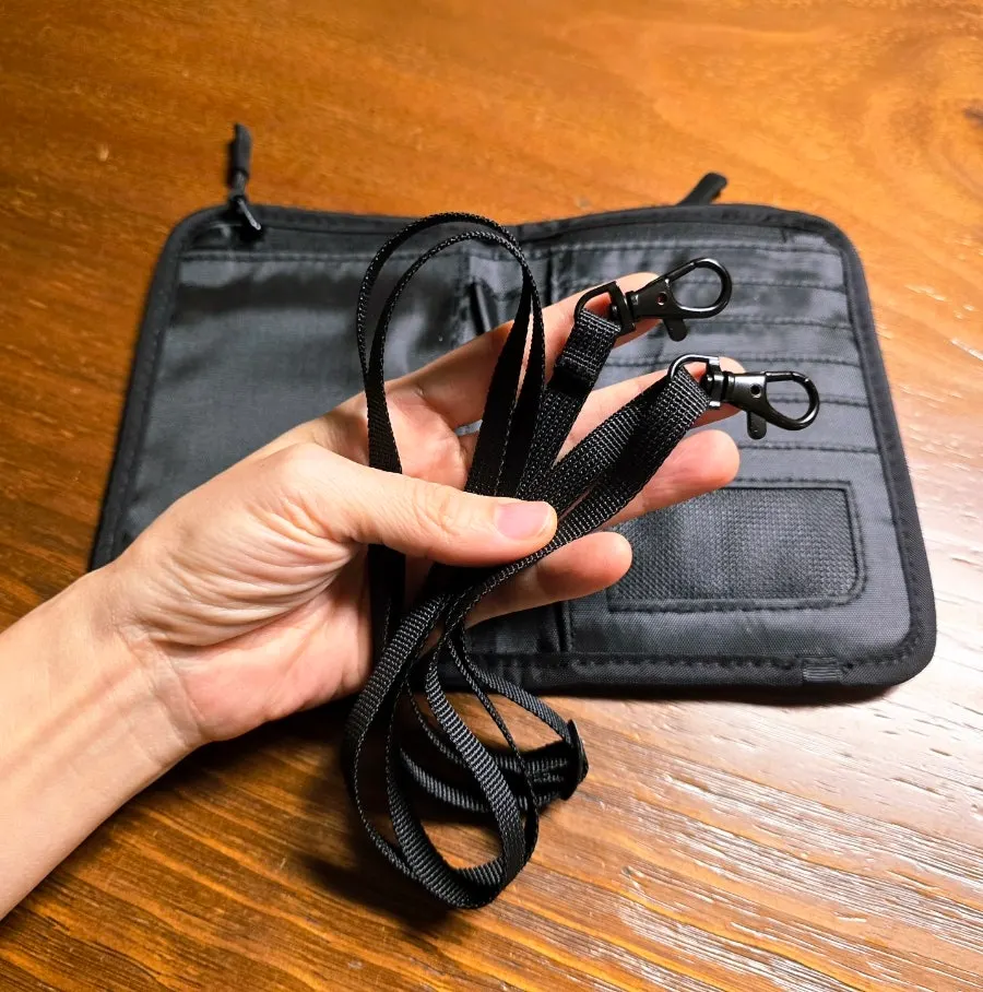 Black passport wallet with an included crossbody strap