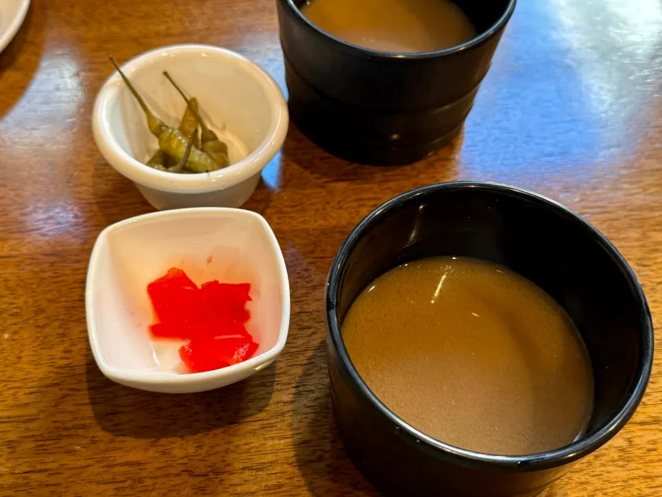 Basic table setting of pickled radish, pickled peppers, and broth