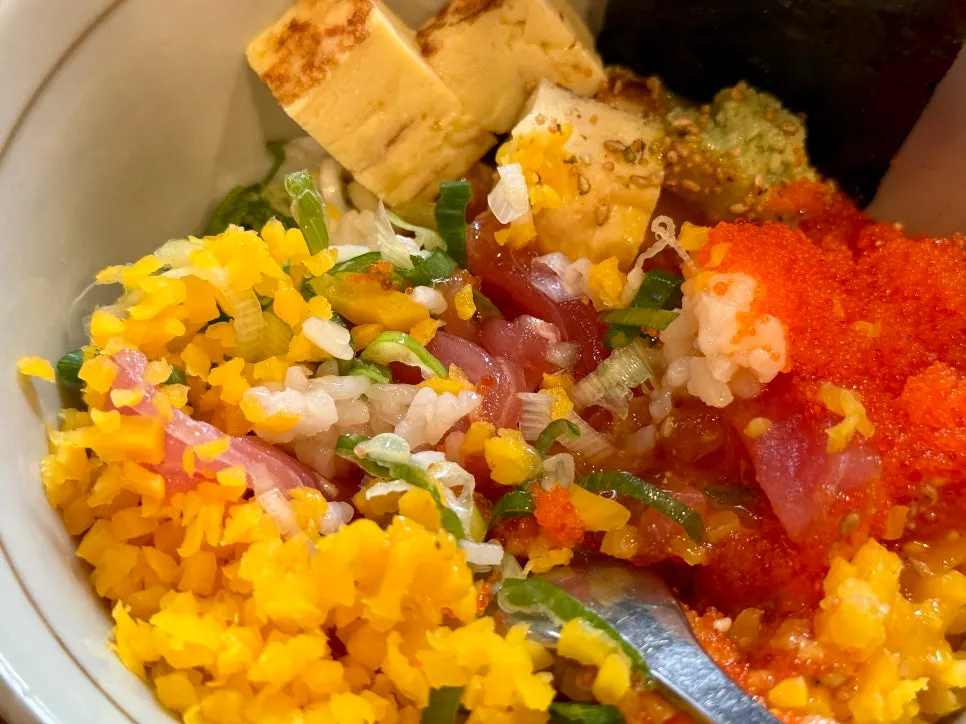 Tuna rice bowl served with seaweed, wasabi, and rolled egg