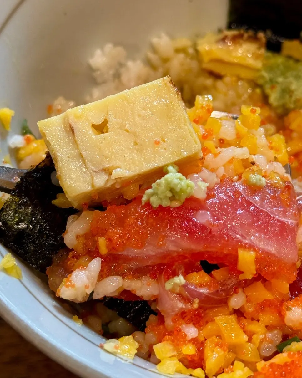 A spoonful of rice bowl mixed with tuna and flying fish roe
