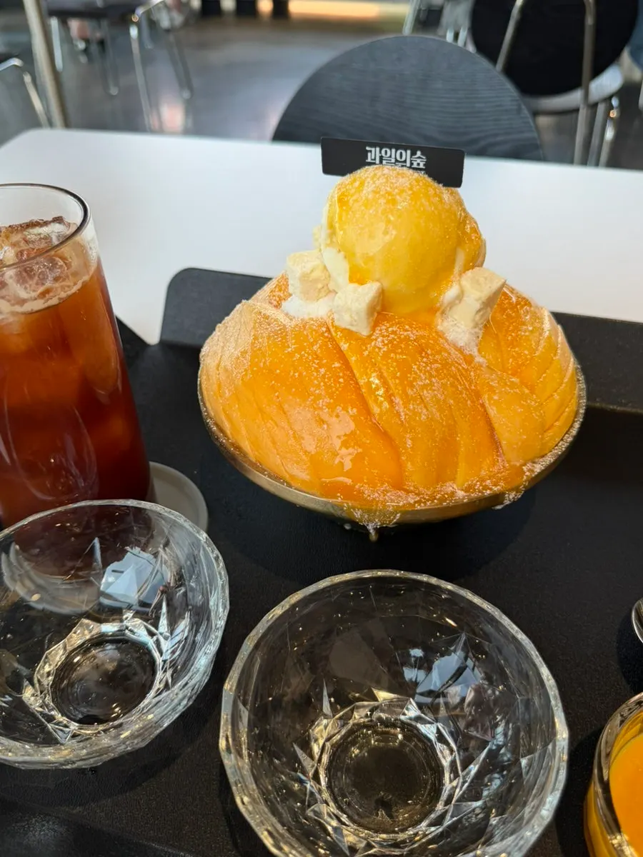 Fresh mango snow bingsu and iced americano served on the table