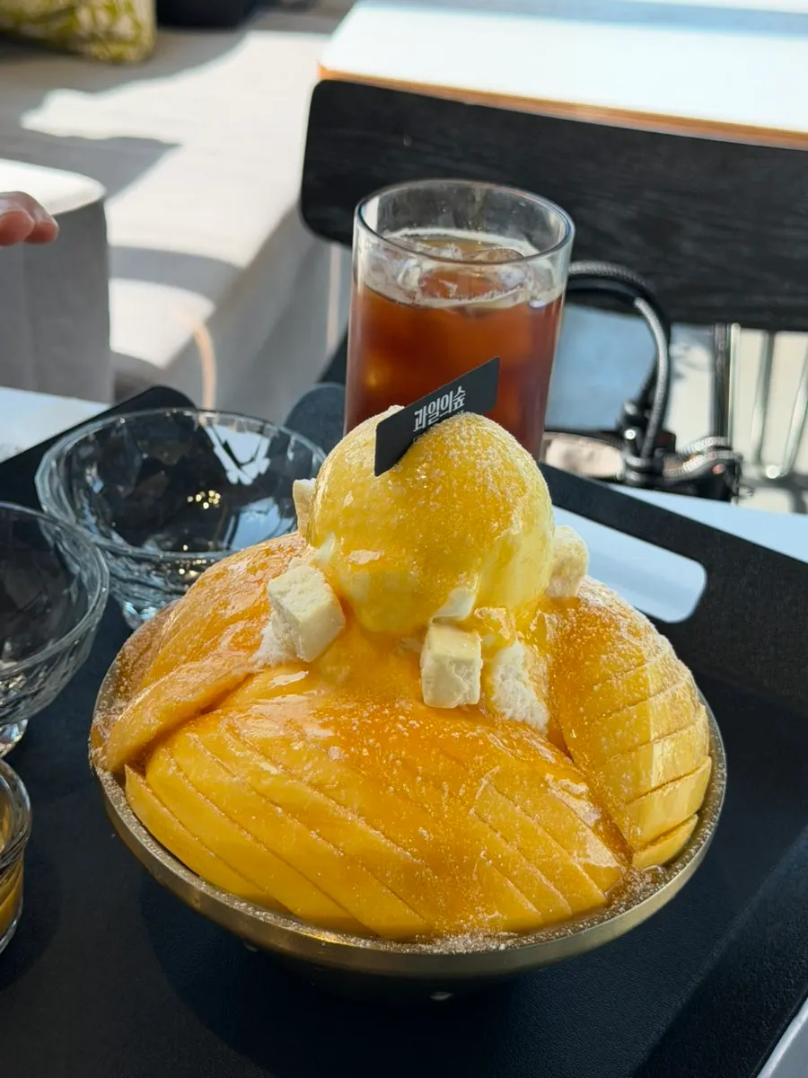 Mango bingsu topped with ice cream and cheese cubes