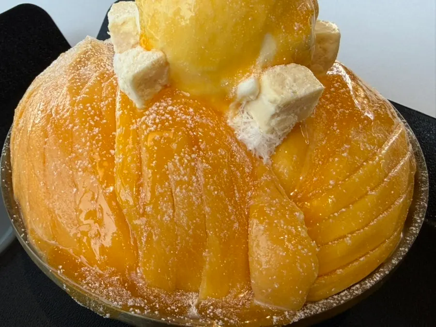 Mango bingsu and mango syrup set on the table