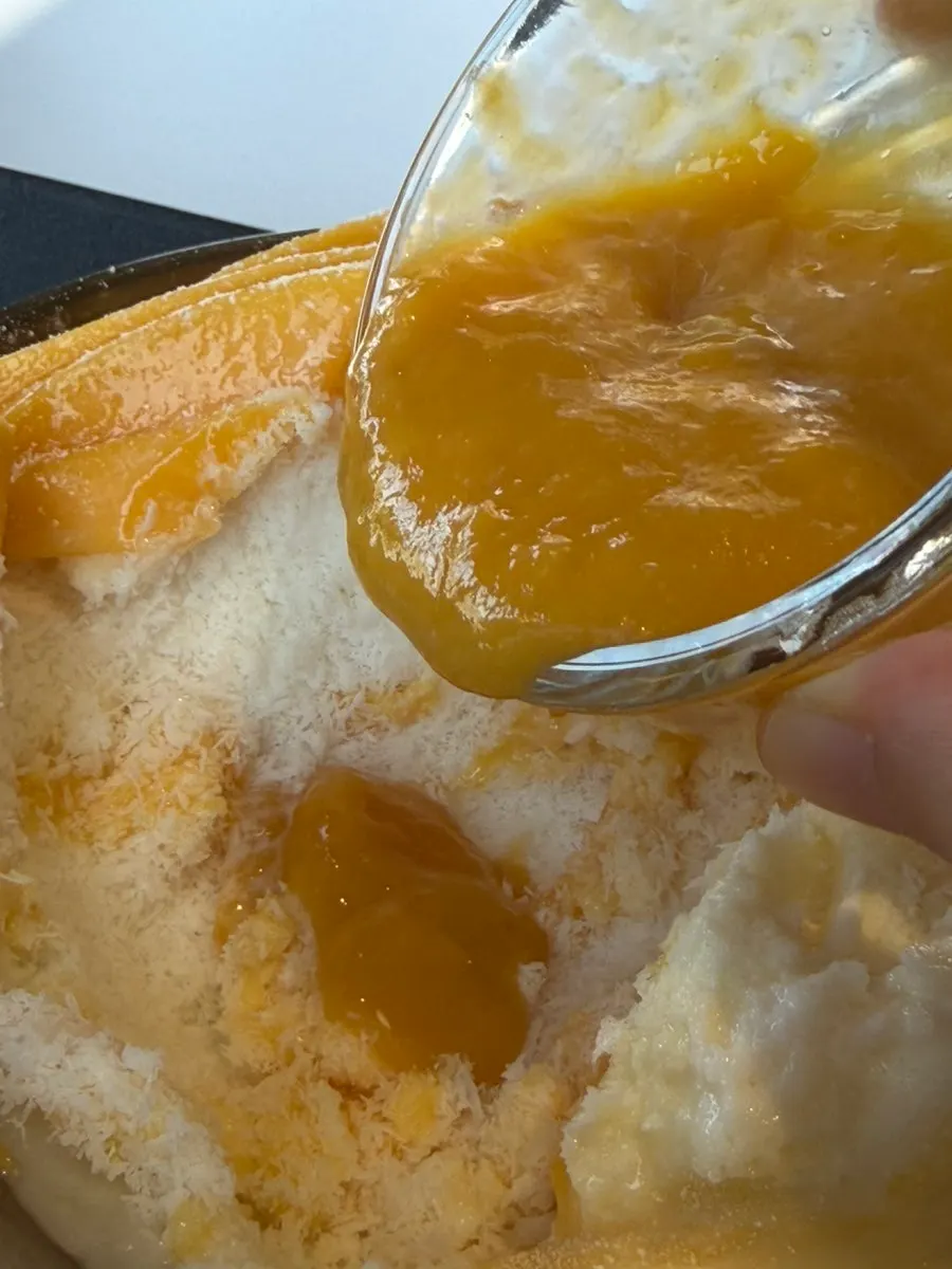 Partly eaten fresh mango snow bingsu with snow ice