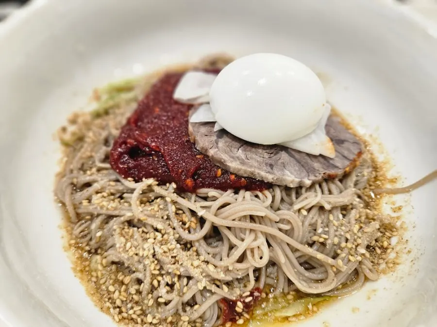 Pyeongyang bibim makguksu topped with perilla oil and ground perilla seeds