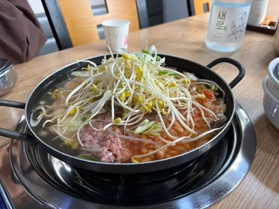 Budae jjigae table setting with assorted add-ins