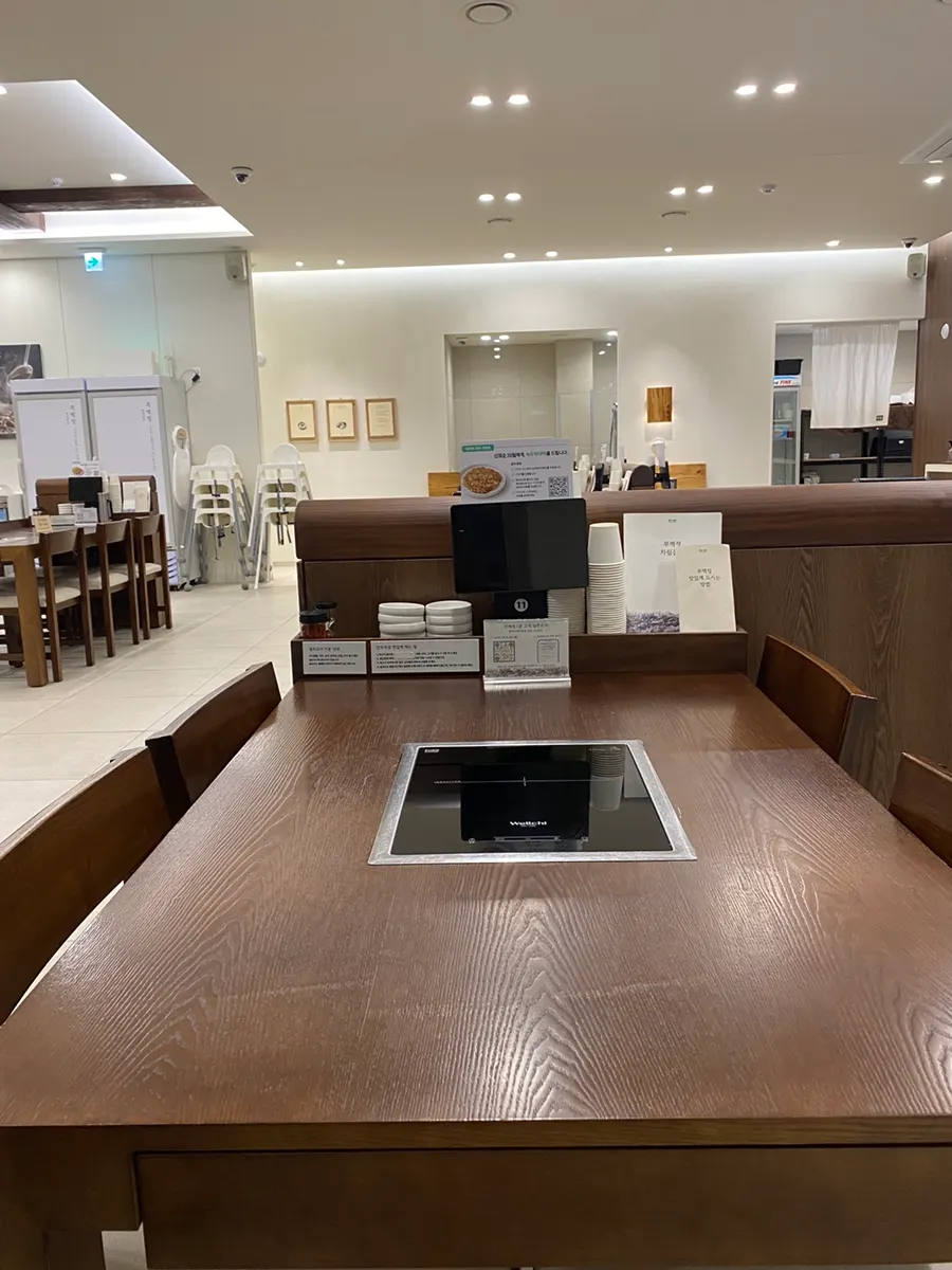 Dining table beside full-height windows and the spacious interior