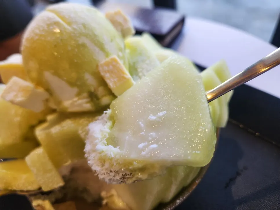 Close-up of melon snow bingsu topped with ice cream