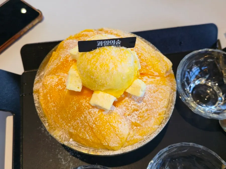 Bingsu served with a small plate and mango sauce