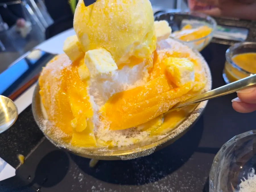 Fresh mango bingsu portioned onto a small plate