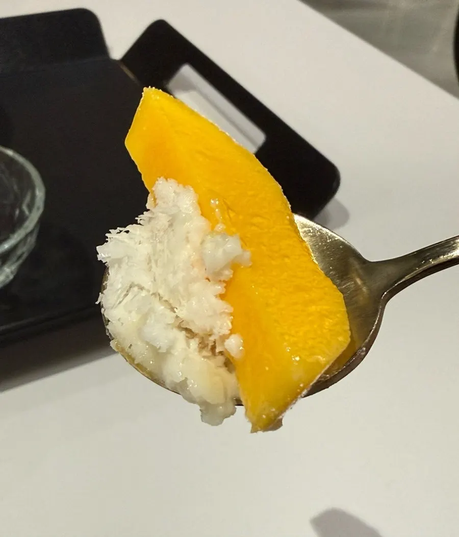 Bingsu ais salji mangga segar dituang ke pinggan kecil untuk dimakan