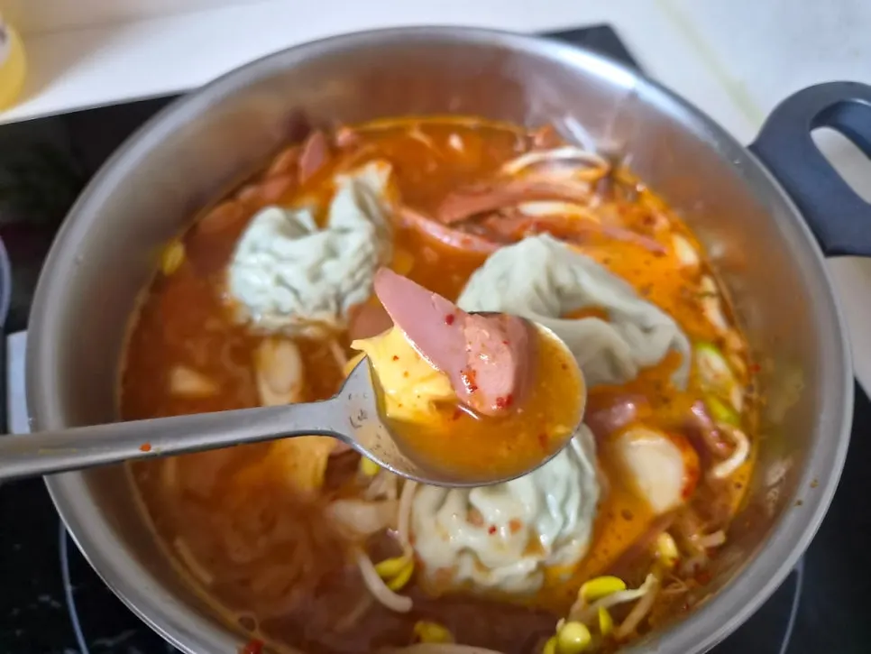 Two servings of basic budae jjigae transferred into a pot to boil