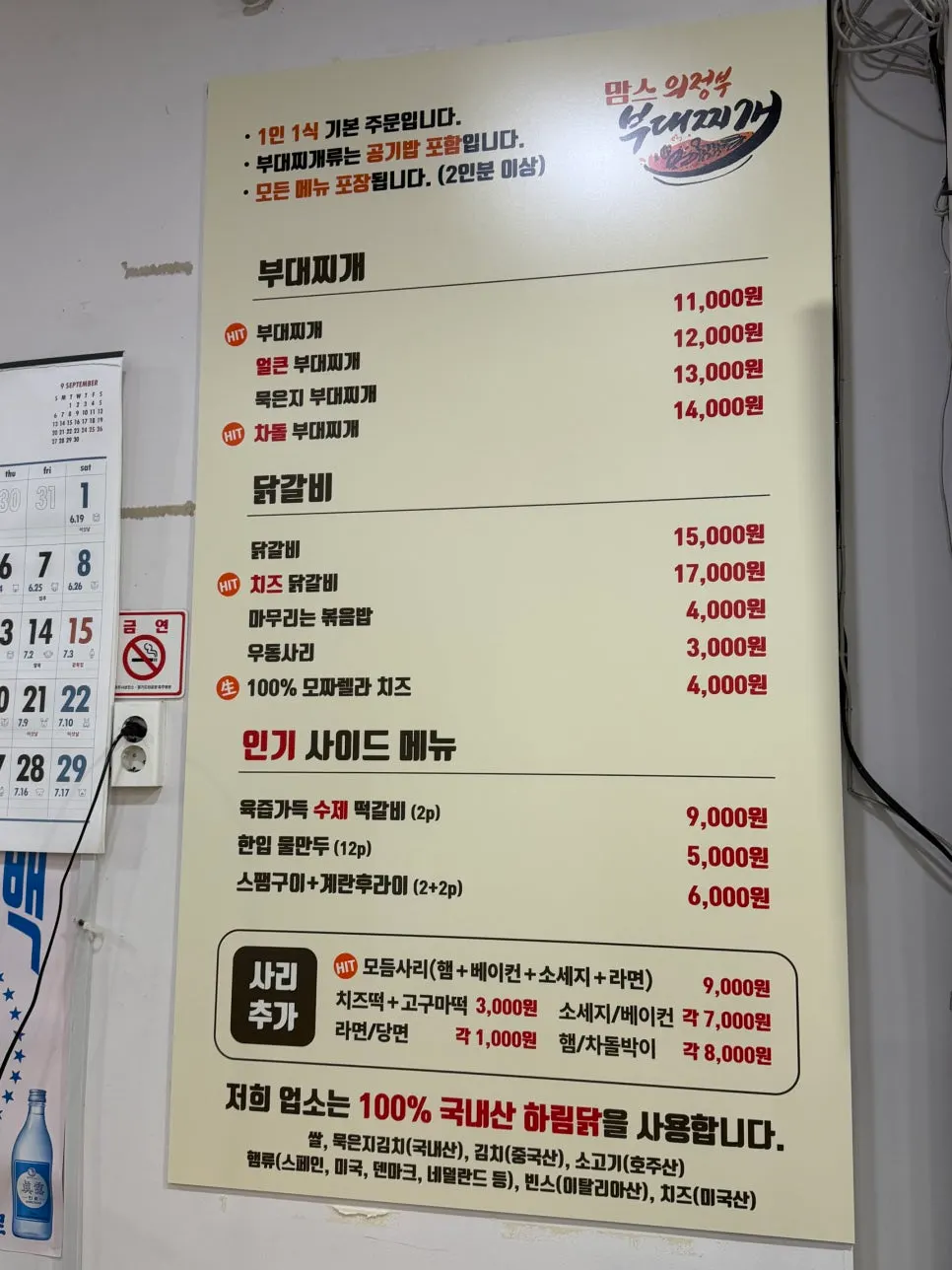 Menu board listing budae jjigae and dakgalbi