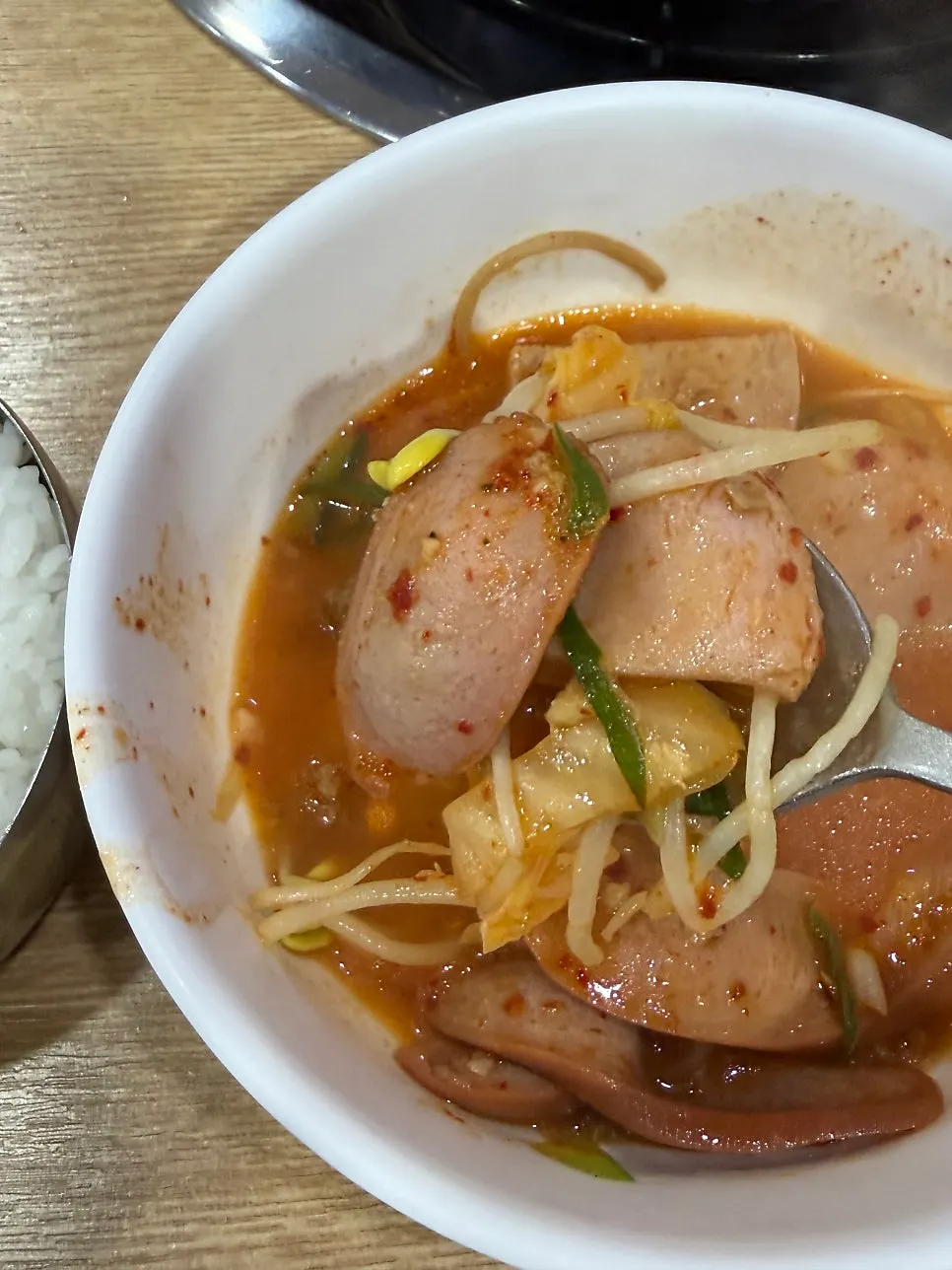 Ham, rice cake, and glass noodles lifted out of the pot