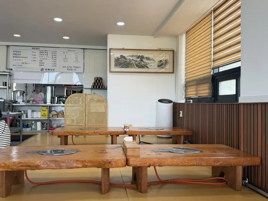 Dining hall seating at Cheonje Guksu with customers