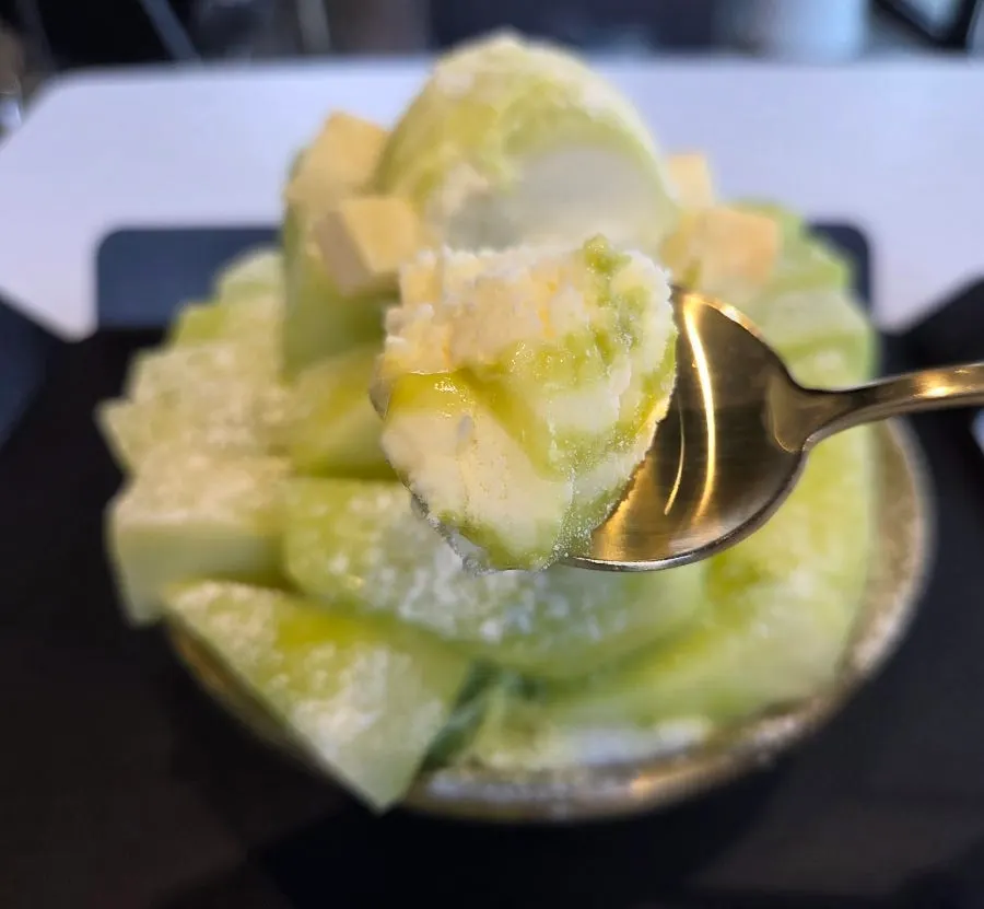 Spoonful of the melon snow bingsu lifted up