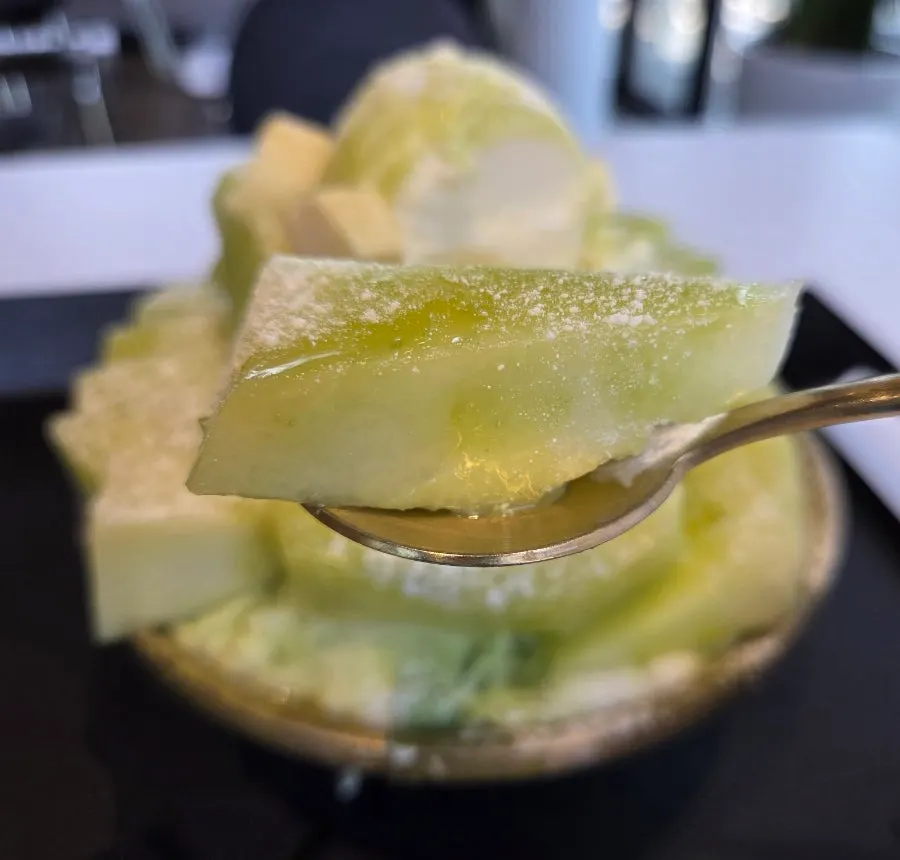 Melon sauce drizzled generously over the bingsu