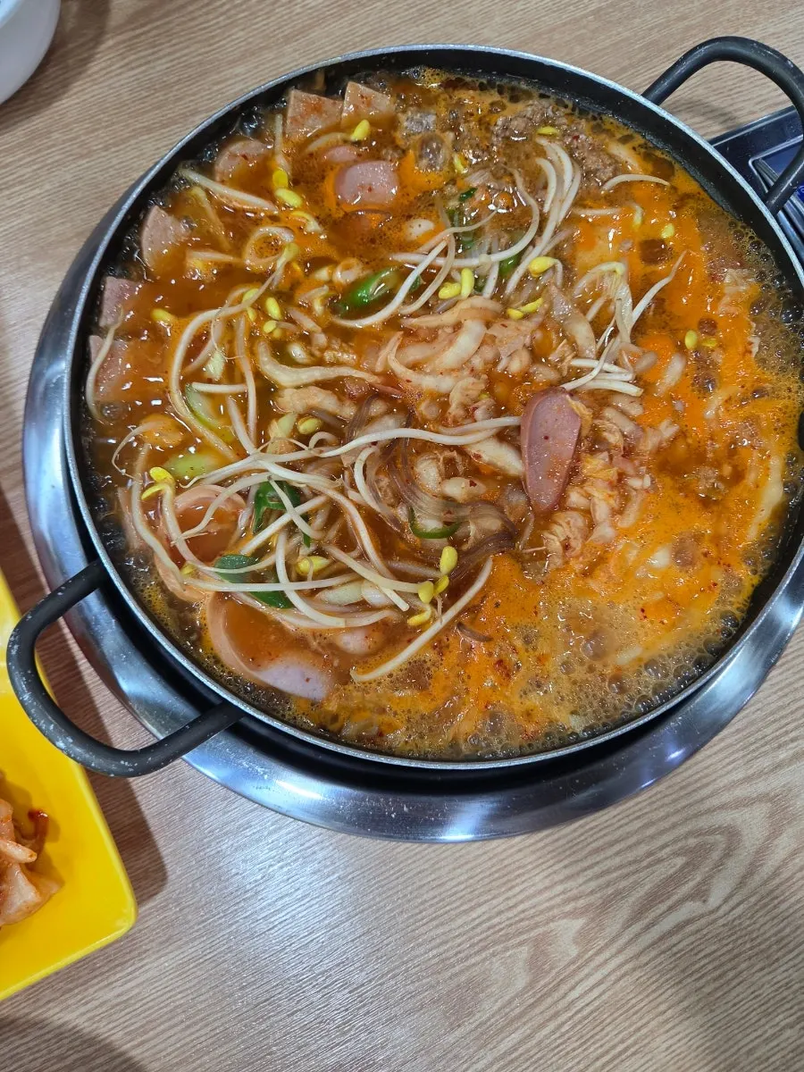 Hot pot of budae jjigae loaded with sausage and bacon