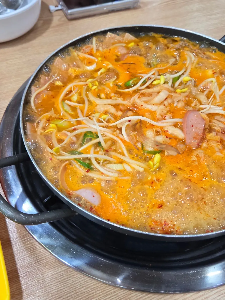 Spoonful of broth lifted from the pot