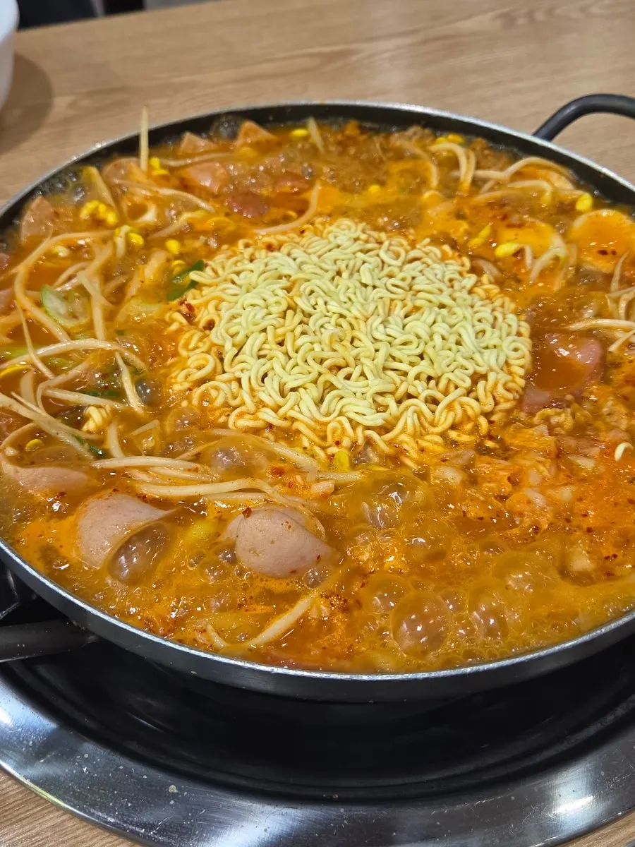 Budae jjigae eaten together with a bowl of rice