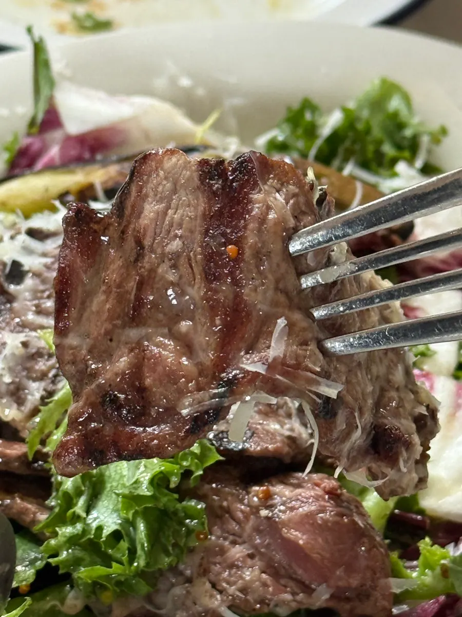 Steak salad topped with bavette and grilled vegetables