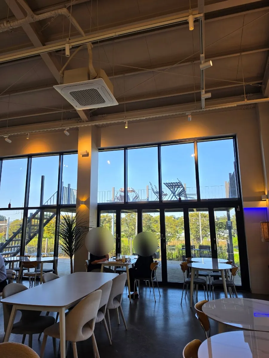 Seat by the floor-to-ceiling window with outside scenery visible at On the Rail