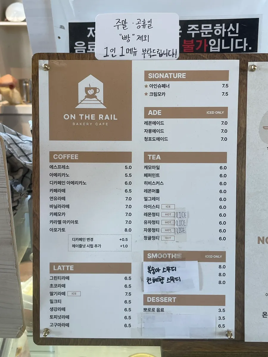 Menu board listing coffee, smoothies, tea, and ades