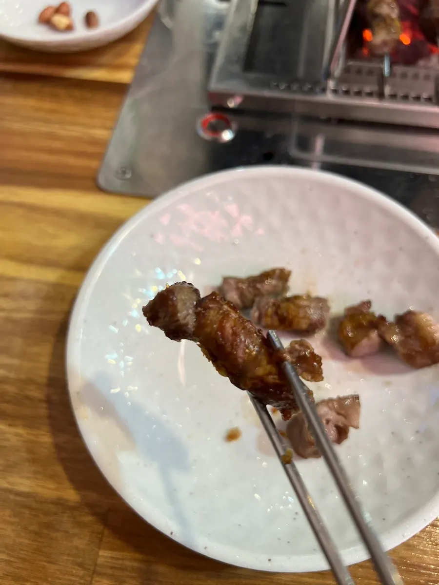 Lamb rib skewers grilling over charcoal