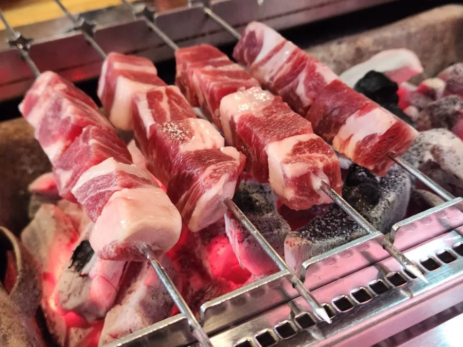 Lamb skewers cooking on the auto-rotating grill