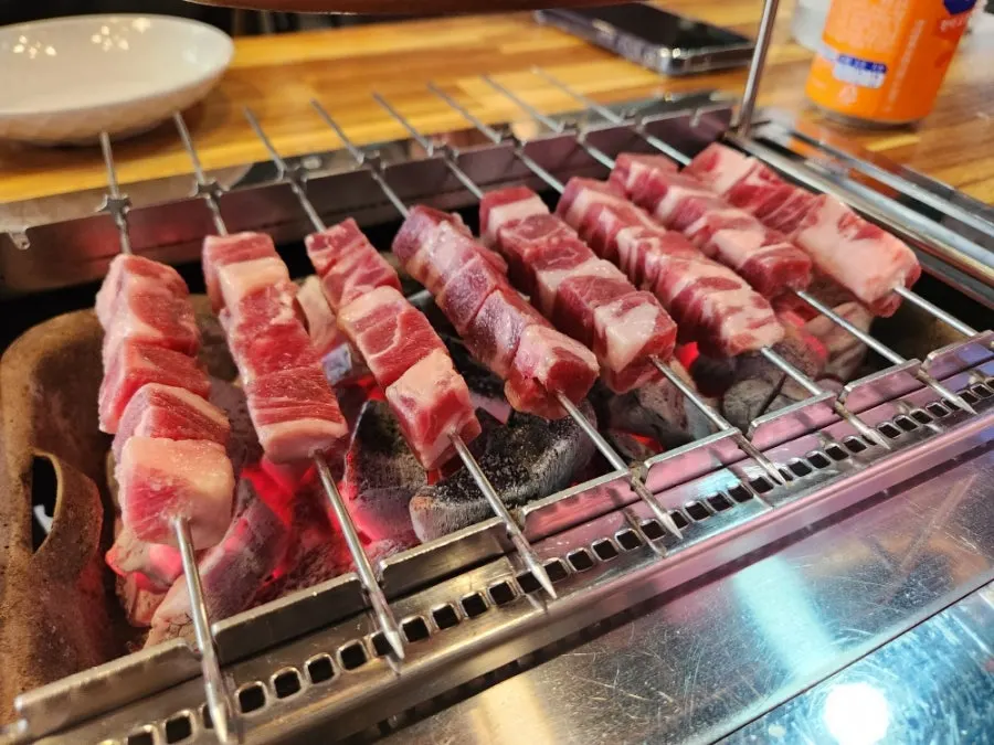 Close-up of lamb skewers as they cook
