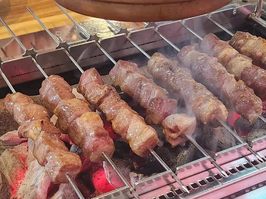 A glass of beer alongside the lamb skewers