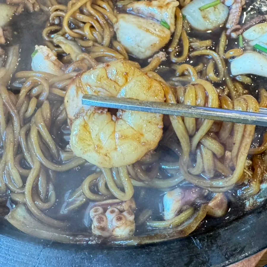 A chopstick full of noodles mixed with jajang sauce