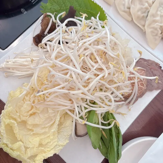 만두와 야채가 수북한 전골 접시