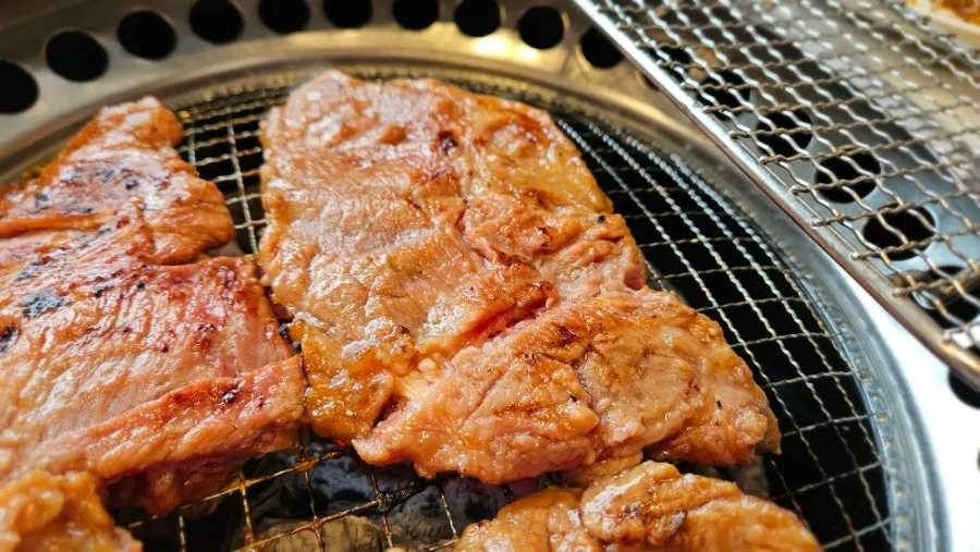 Marinated pork ribs cooking over charcoal